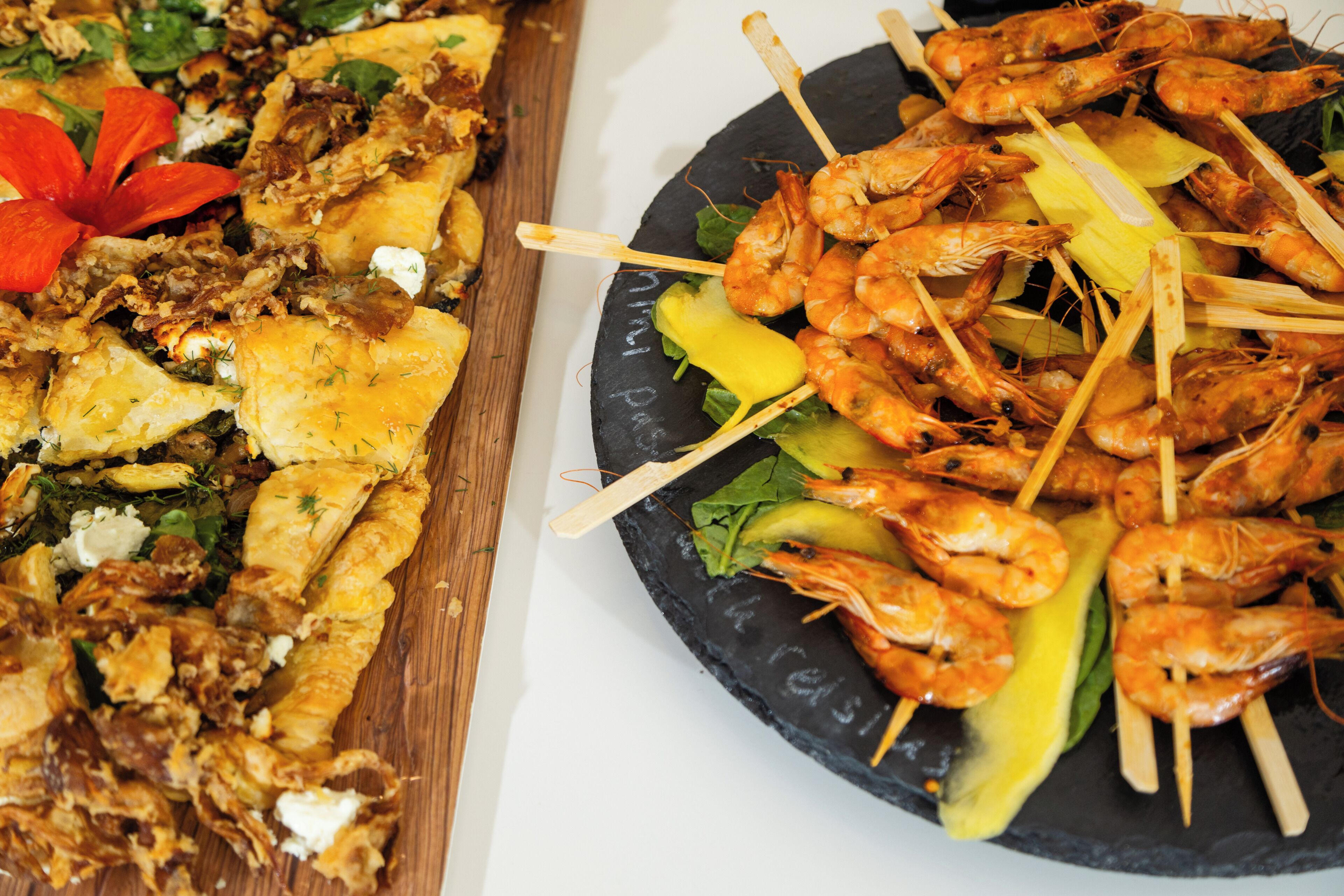 A variety of food items including skewered shrimp and other dishes on a platter.