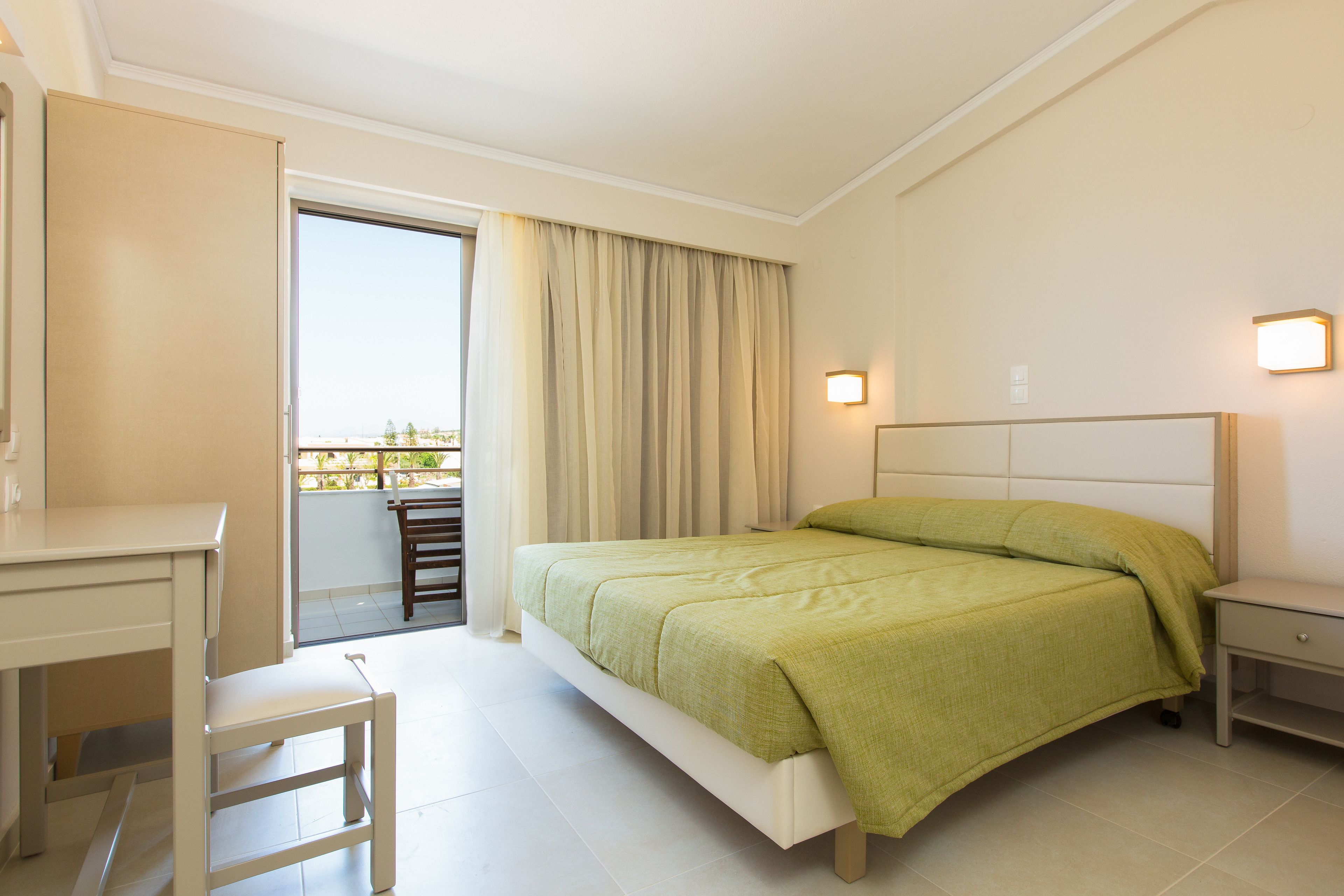 Une chambre à coucher comprenant un lit, un bureau, une chaise et une table de chevet.