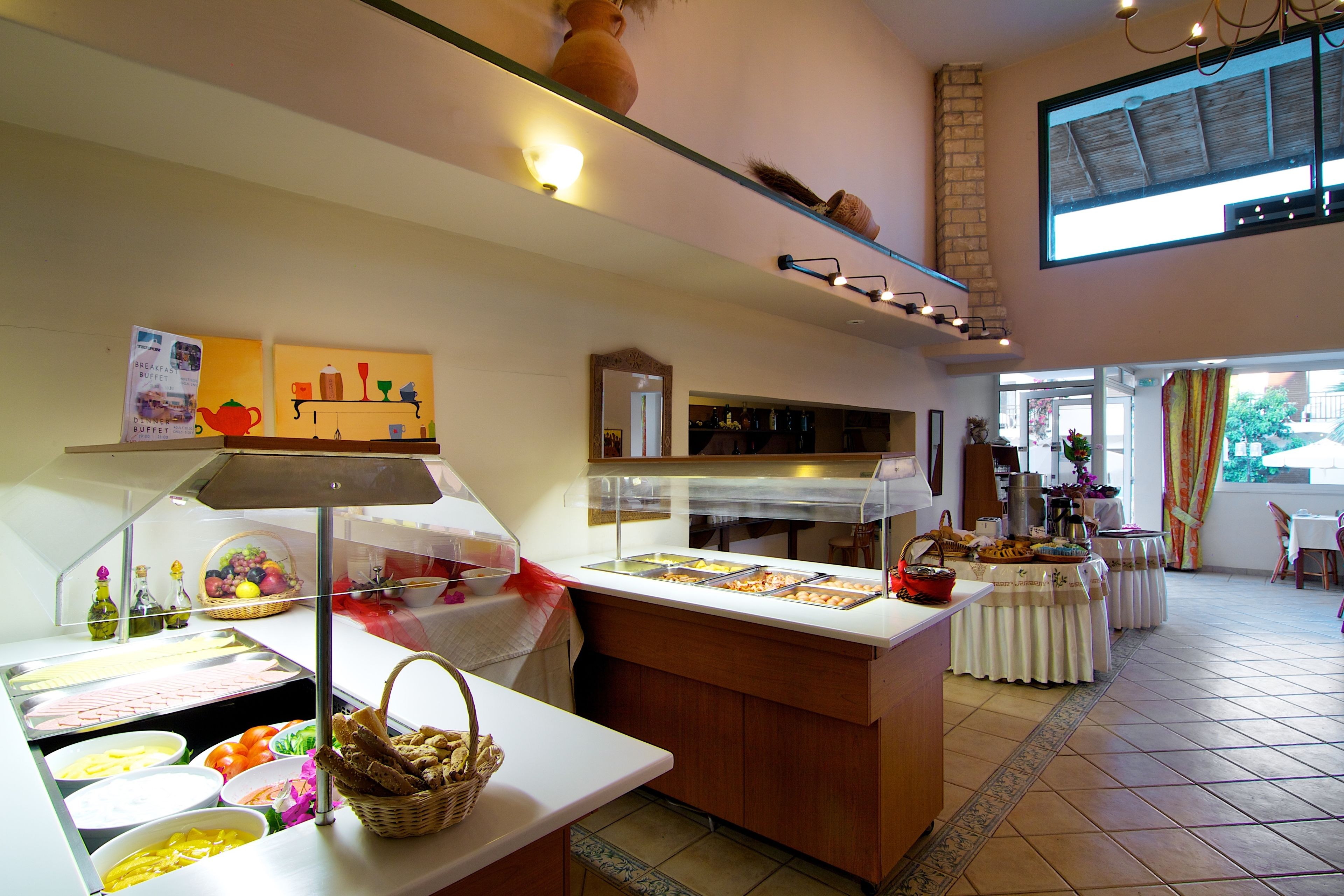 Un'area buffet con diversi cibi e un'area salotto con tavoli e sedie.