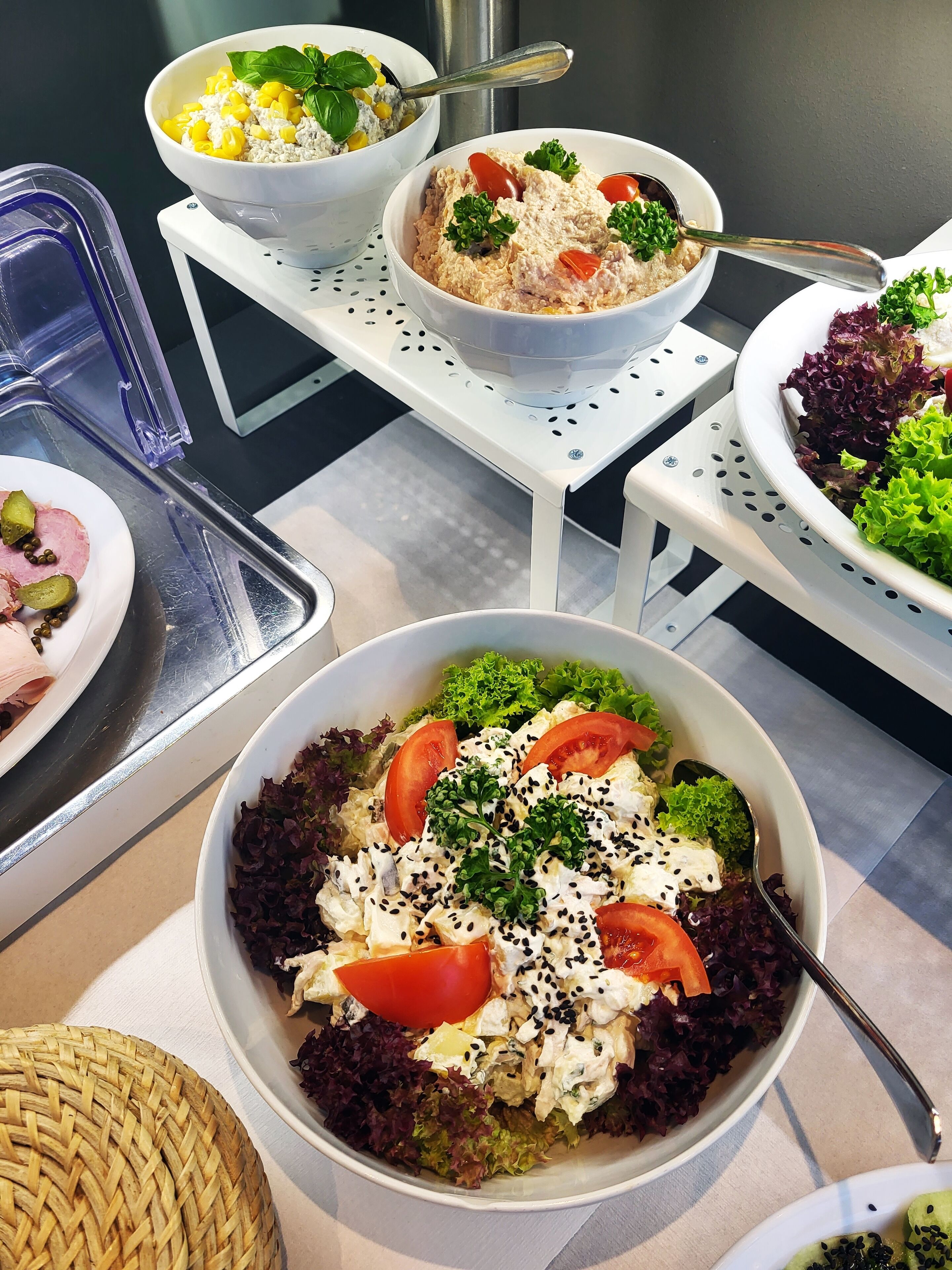 A buffet with various dishes including salads, rice, and a dish with corn and cheese.