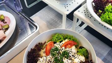 A buffet with various dishes including salads, rice, and a dish with corn and cheese.