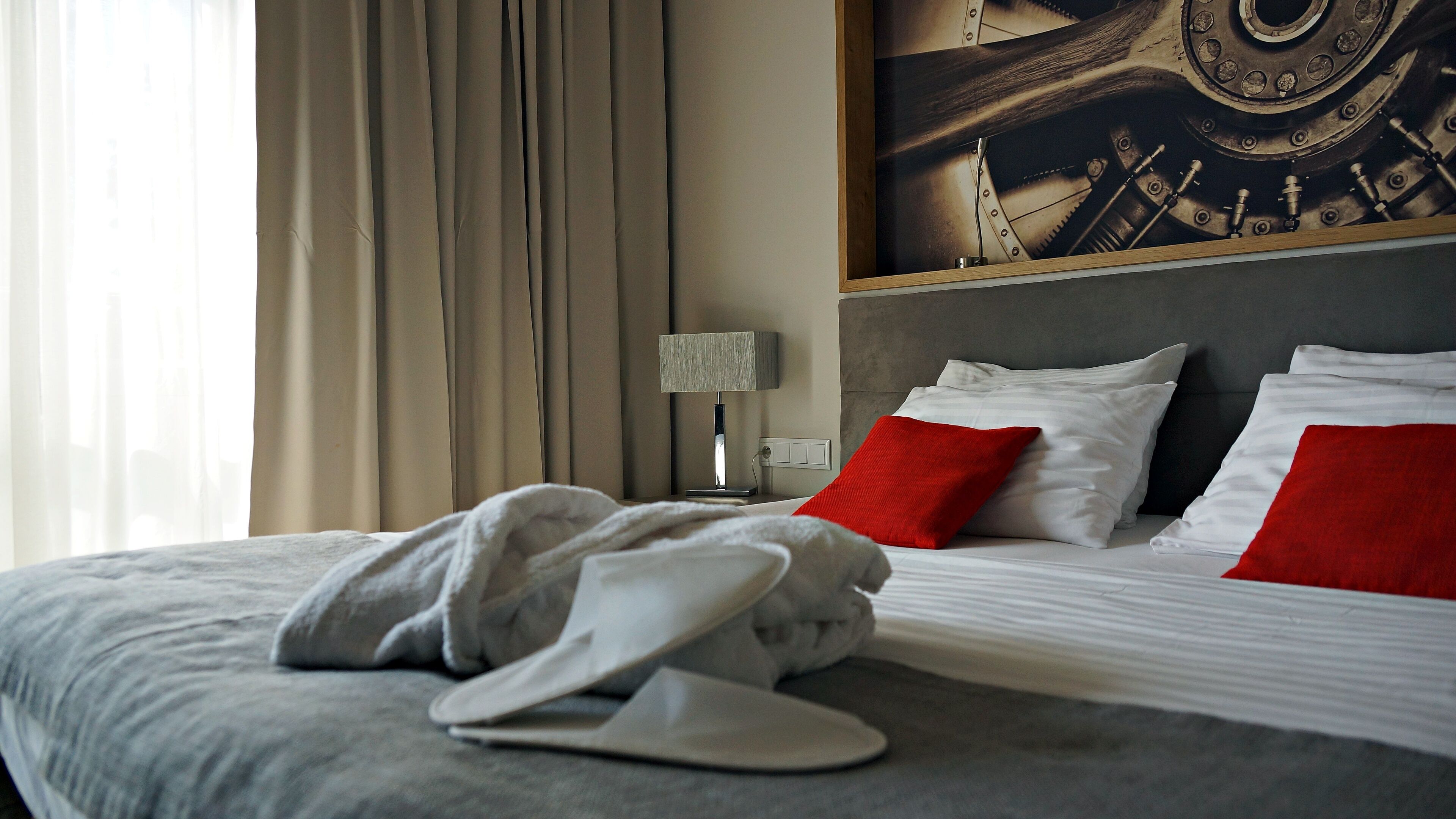 Une chambre d’hôtel avec un lit, une table de chevet avec une lampe et un tableau au mur.