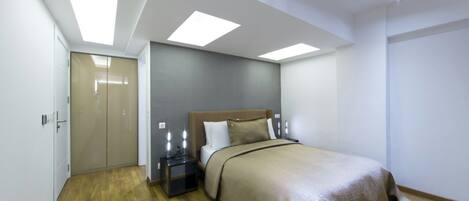 A bedroom with a bed, bedside tables, and a wardrobe.