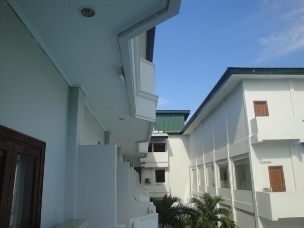 A modern building with white exterior walls and balconies.