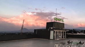 A hotel rooftop with a clear view of the sky and distant mountains. - IZI Hotels (Bogor)