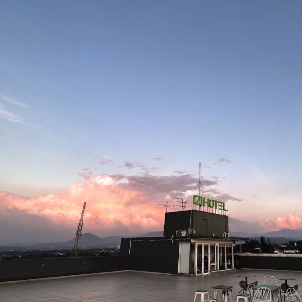 Une terrasse d’hôtel offrant une vue dégagée sur le ciel et les montagnes lointaines.