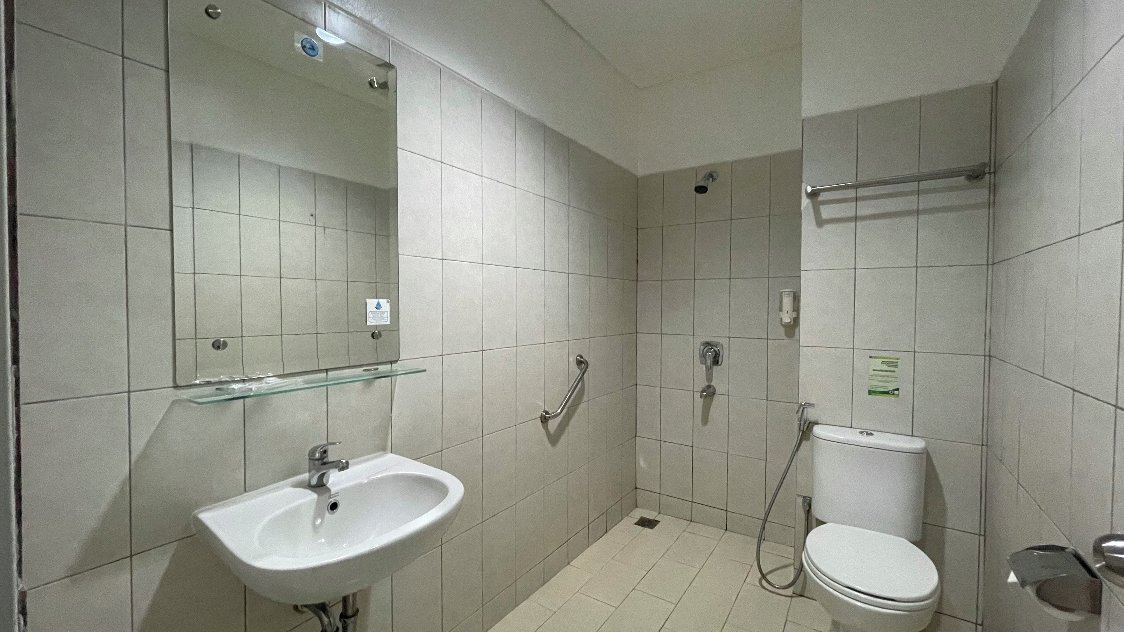 Une salle de bain moderne équipée d’un lavabo, d’un miroir, de toilettes et d’une douche.