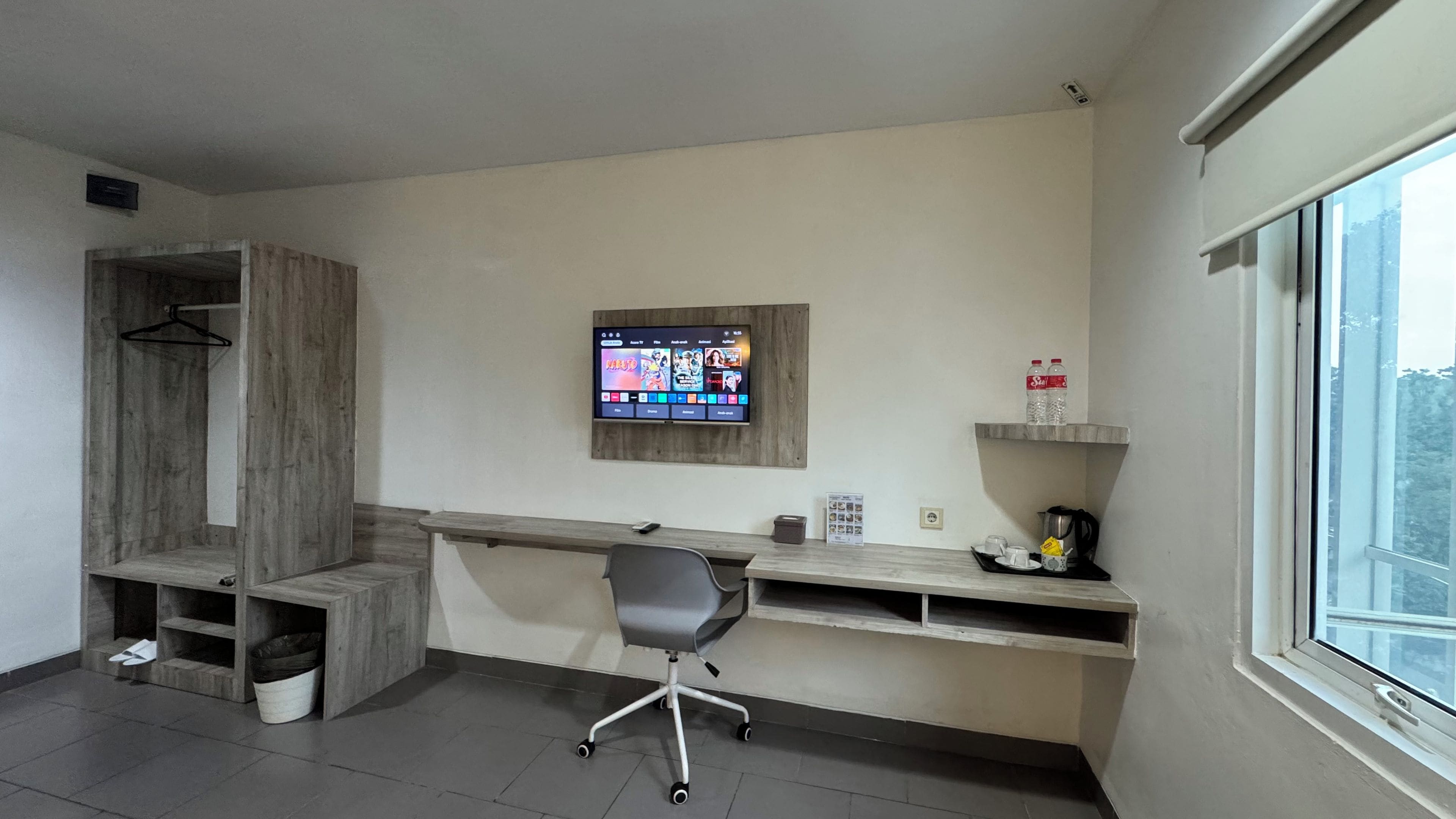 A modern office space with a desk, chair, and a mounted TV displaying a streaming service interface.