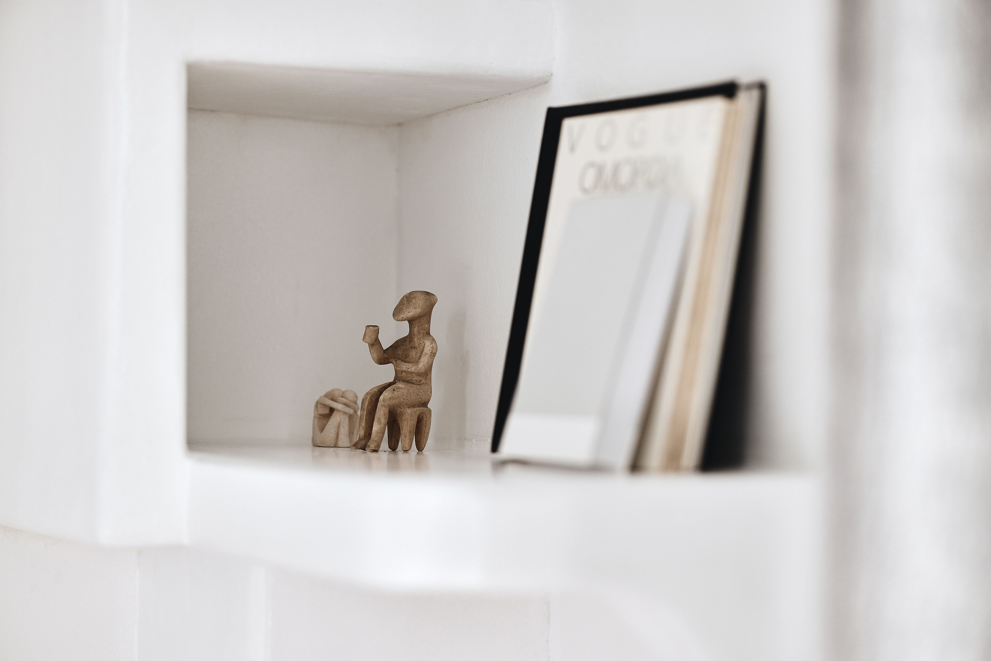 A white shelf with a framed picture and a small figurine.