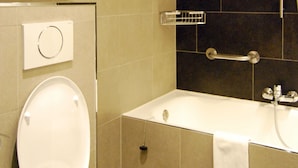 Un baño con inodoro, bañera y ducha.
