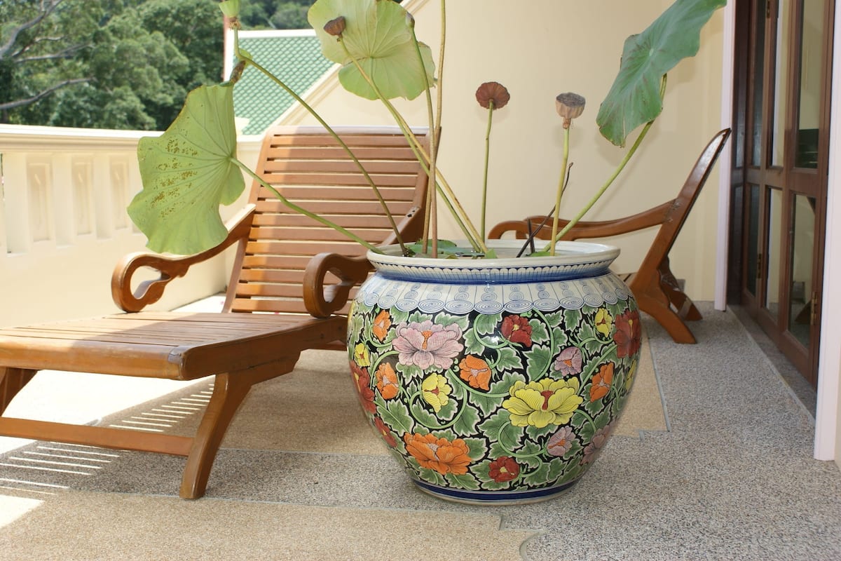 A large decorative pot with floral patterns on a balcony.