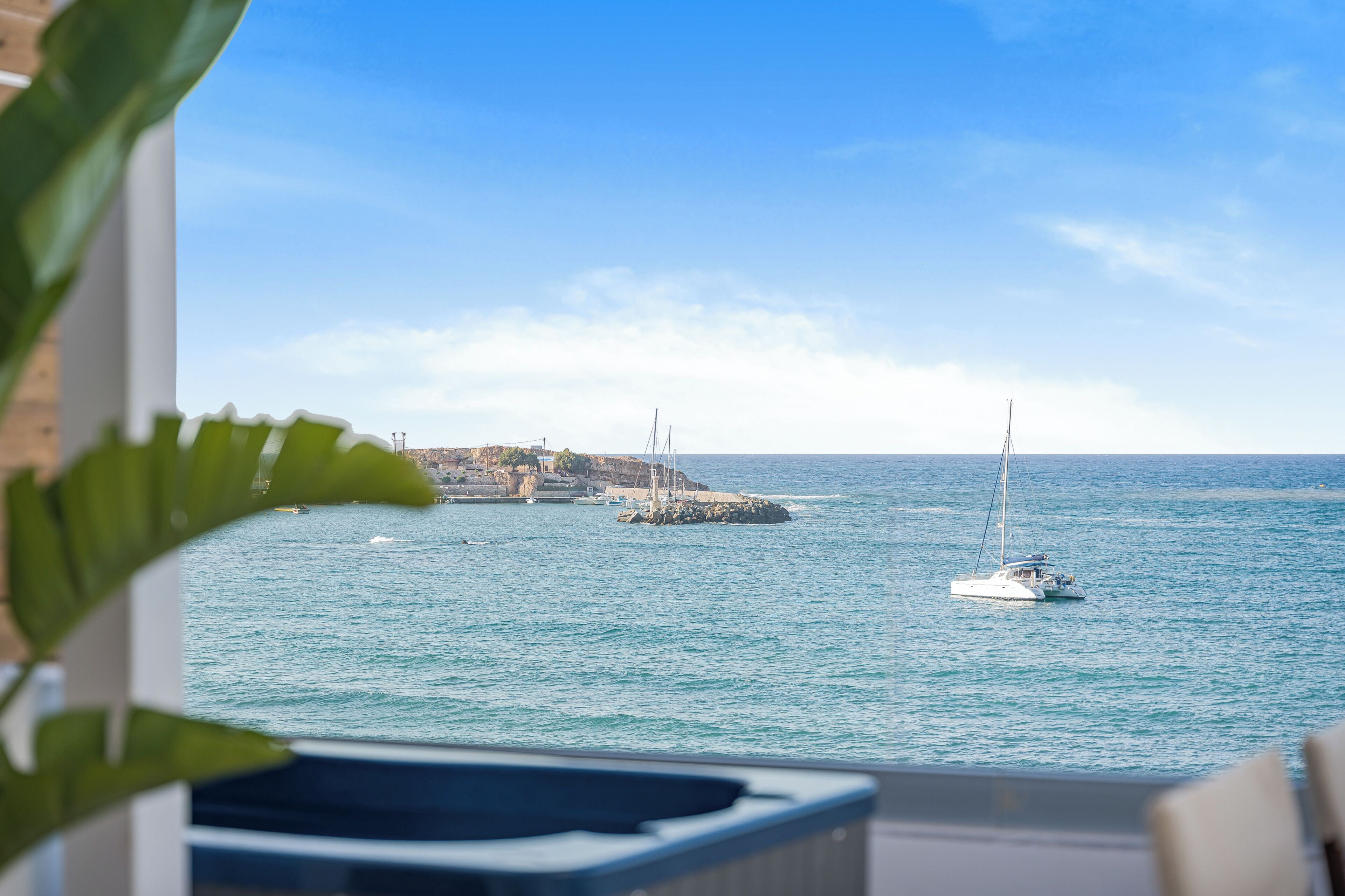 Une vue sur la mer, avec des bateaux et une côte rocheuse.