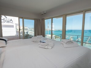 A hotel room with a large bed, two towels, and a view of the sea. - Kahlua Boutique Hotel - Adults Only (Hersonissos)