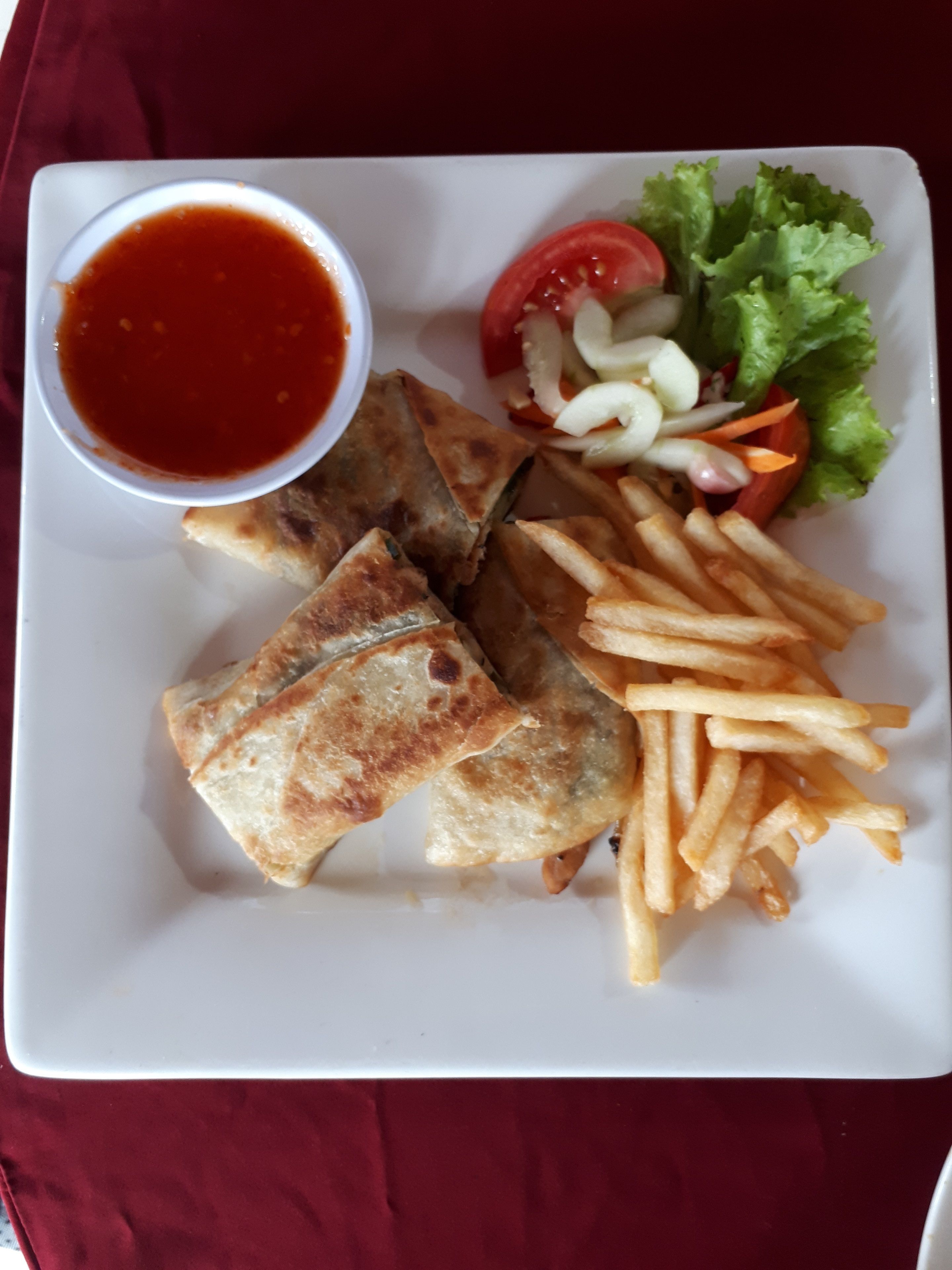 A plate with food including fried items, fries, and a side salad.