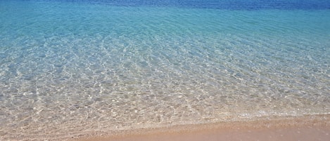 På stranden, solsenger, parasoller og snorkling
