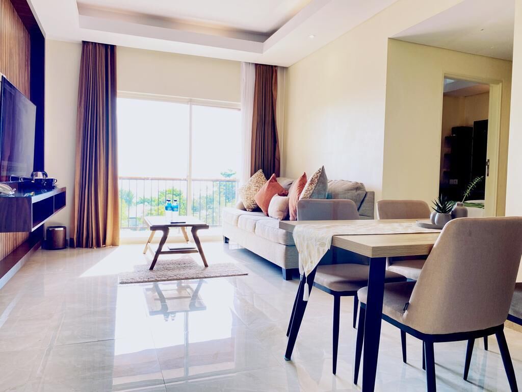 Una sala de estar moderna con un sofá, una mesa de comedor y un televisor.
