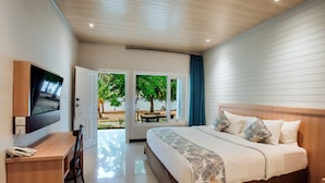 Ein Hotelzimmer mit Bett, Schreibtisch, Fernseher und Blick ins Freie.