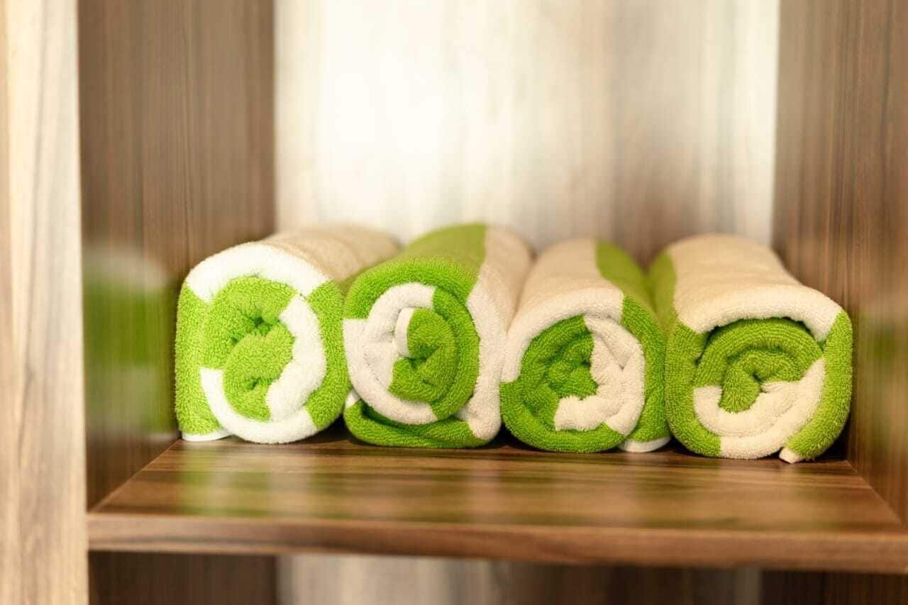 A set of neatly rolled towels in a wooden cabinet.