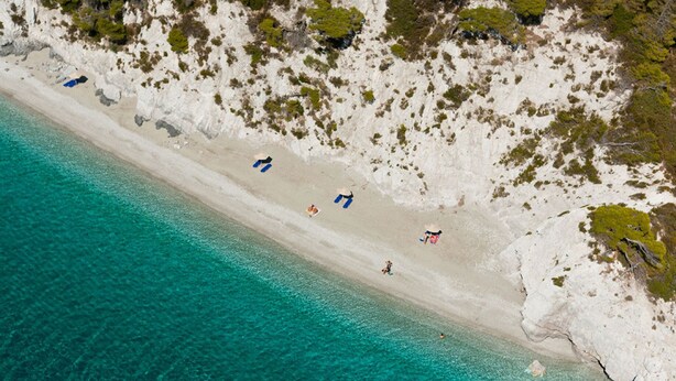 An aerial view of a beach with clear turquoise waters and white sand. - Hovolo Hotel Apartments (Skopelos)