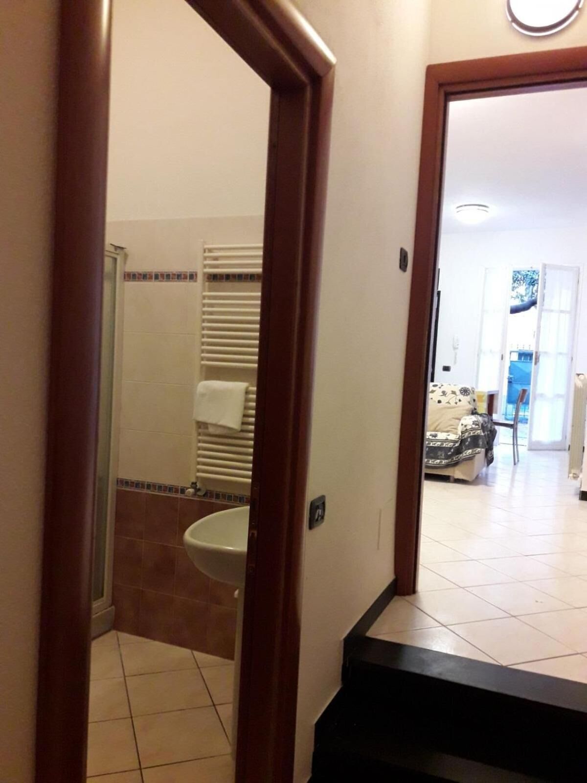 A bathroom with a toilet, a shower, and a towel rack.