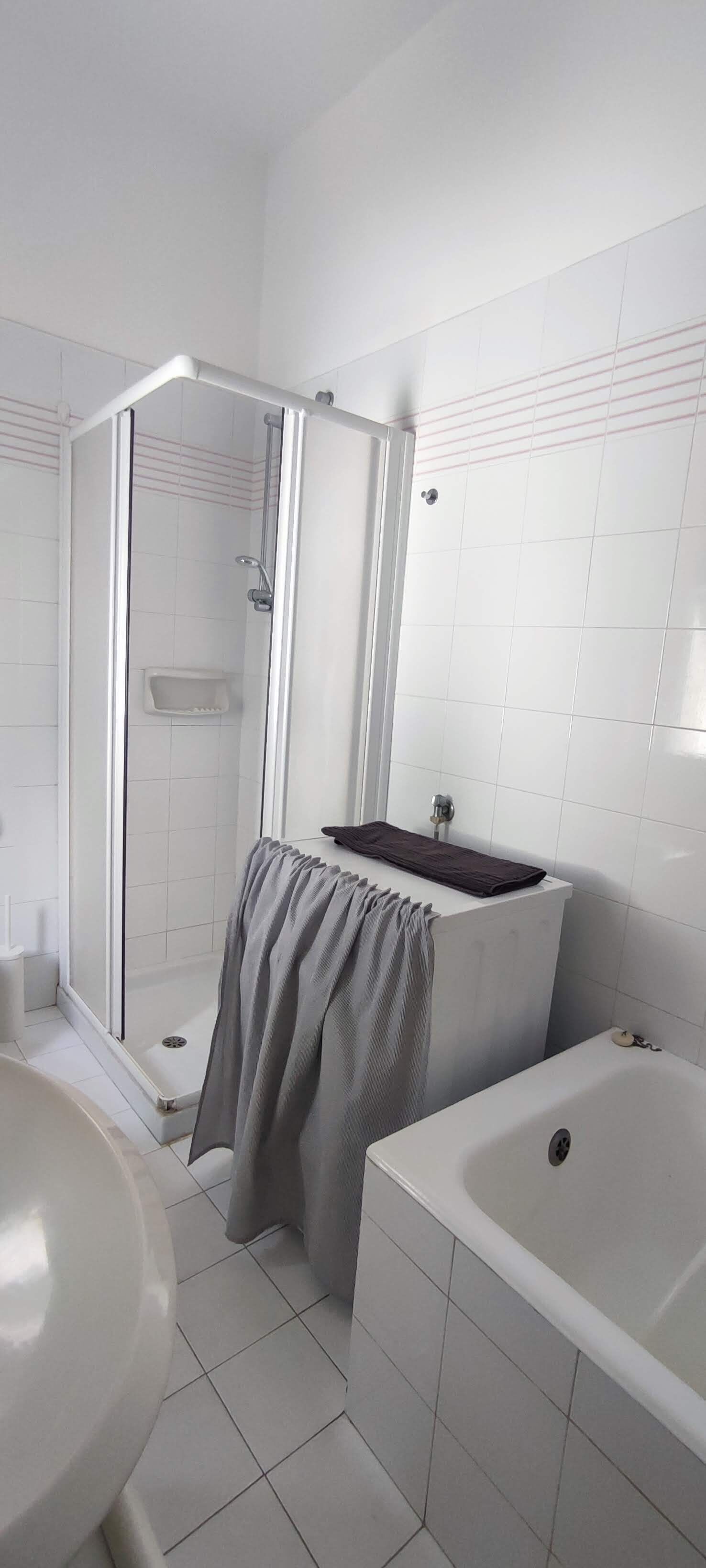 Un baño con ducha, lavamanos y bañera.