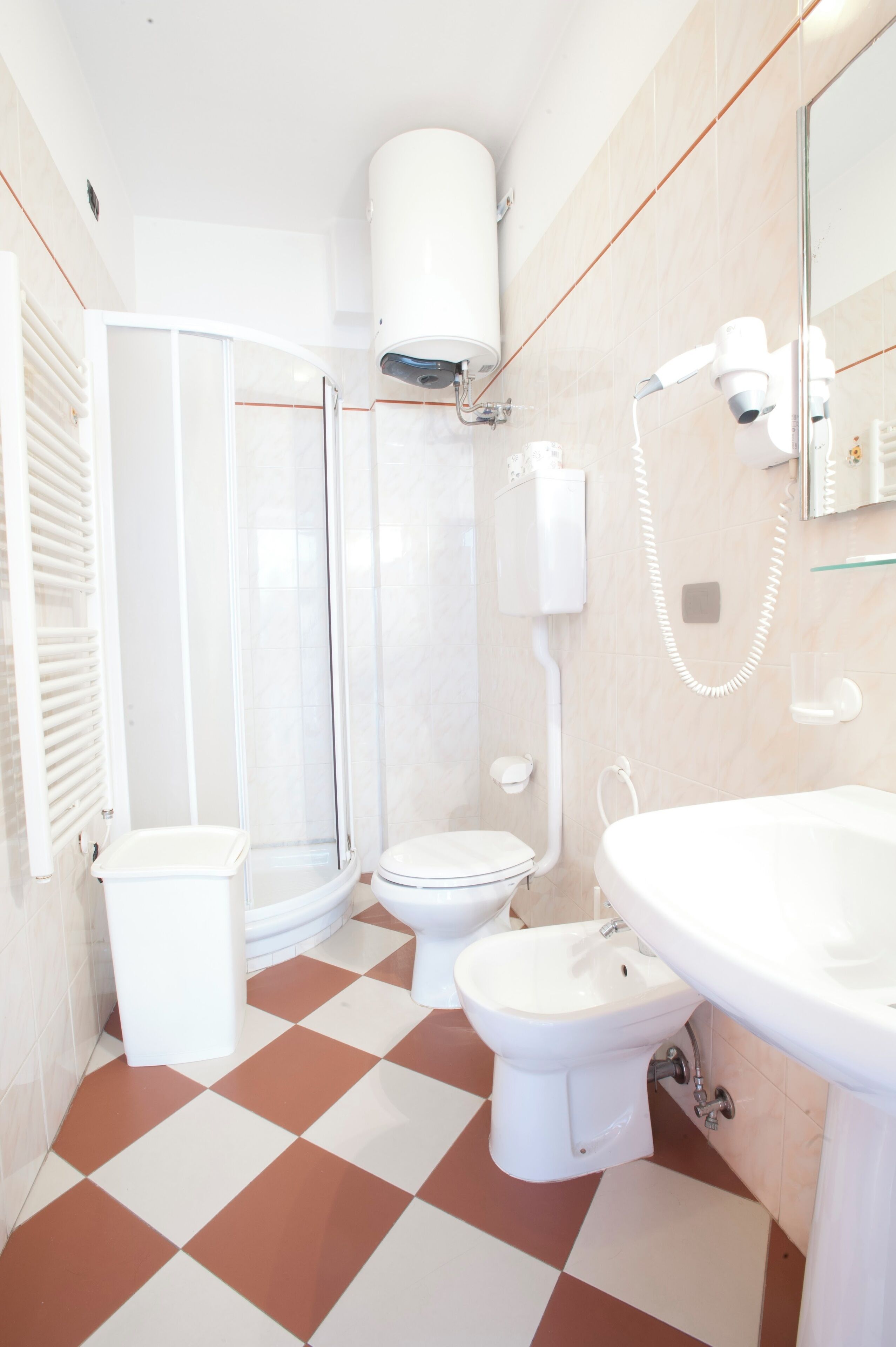 Ein Badezimmer mit Dusche, Toilette, Bidet und Waschbecken.