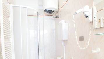 Ein Badezimmer mit Dusche, Toilette, Bidet und Waschbecken.