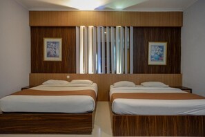 Una habitación de hotel con dos camas, cabeceros de madera y obras de arte enmarcadas en las paredes.