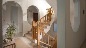 A staircase with wooden railings and beige steps, leading to an upper floor. - Meltemi Hotel (Milos)