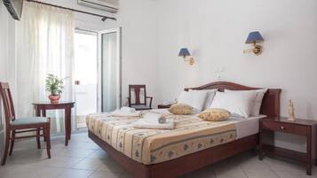 Una habitación de hotel con una cama, una silla, una mesita y una mesita de noche.