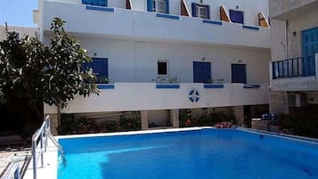 Una piscina al aire libre de temporada, sombrillas