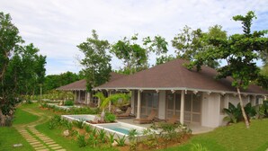 A resort with a pool, lounge chairs, and a well-maintained garden. - Bohol Shores (Dauis)