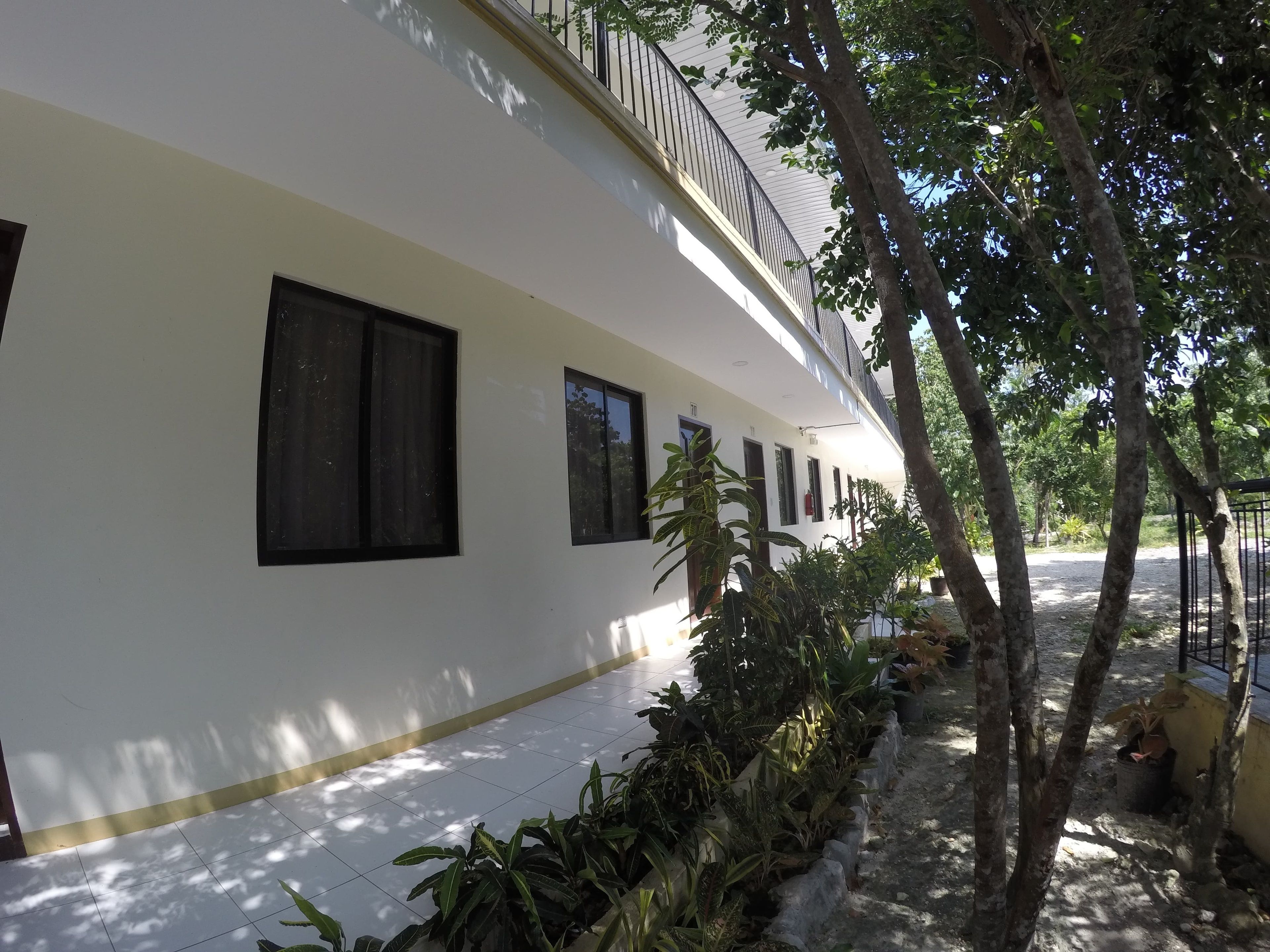Un edificio blanco con múltiples ventanas y un balcón.