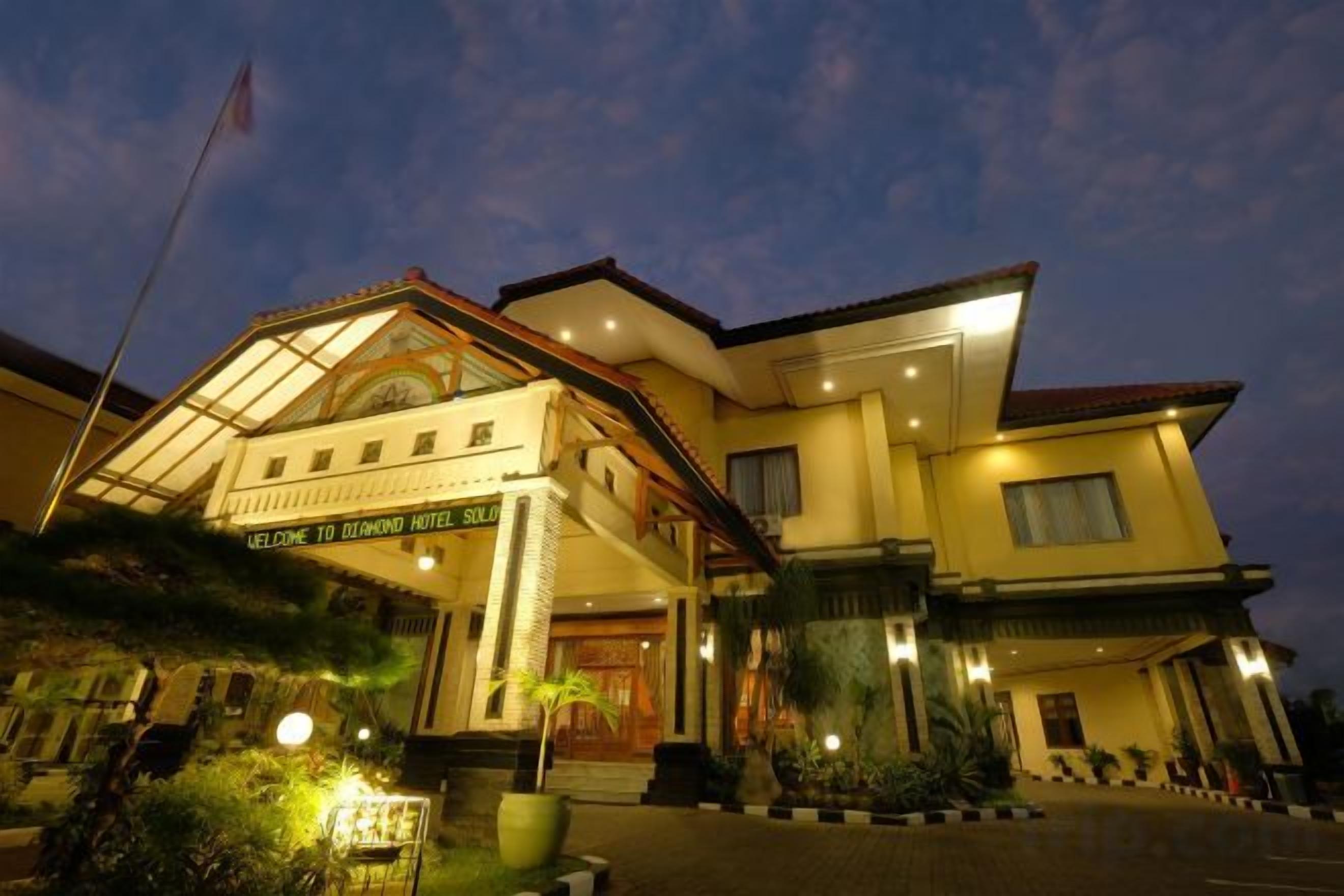 Un hotel con una entrada acogedora, una bandera y un cartel.
