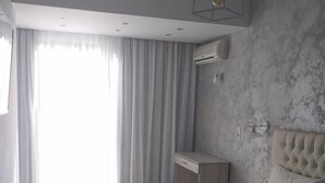 Ein modernes Hotelzimmer mit einem großen Bett, einem Schreibtisch und einem Kleiderschrank.