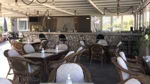 Ein Patio im Freien mit Korbmöbeln, Steinmauern und einer Steinarbeitsplatte mit einem Stier-Mural.