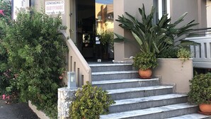 Ein Hotel Eingang mit einem Schild, das "HOTEL APARTMENTS" zeigt, und einer Treppe, die zum Eingang führt.
