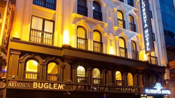 Un hotel de varios pisos con un diseño arquitectónico clásico, que cuenta con balcones y ventanas amplias.