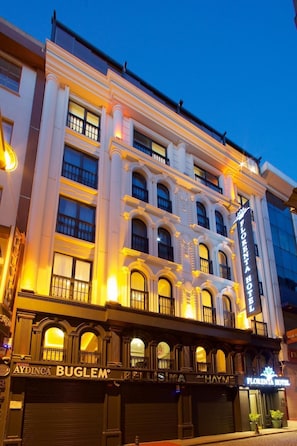 Ein mehrgeschossiges Hotel mit klassischem architektonischen Design, mit Balkonen und großen Fenstern.