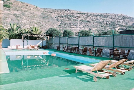 Una piscina al aire libre de temporada, sillones reclinables de piscina