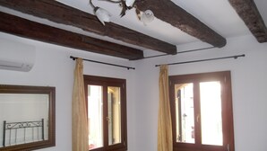 A bedroom with a wooden ceiling, two windows with curtains, a radiator, and a bed. - Sweet Venice - rooms & apartments (Venice)