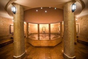 A spacious, well-lit lobby with a central seating area, stone columns, and modern lighting fixtures. - Kimeros Park Holiday Village (Kemer)