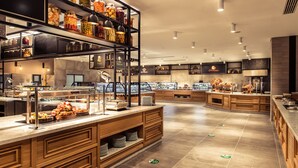 A modern buffet area with multiple food stations, a variety of food items on display, and a clean, spacious layout. - Kimeros Park Holiday Village (Kemer)