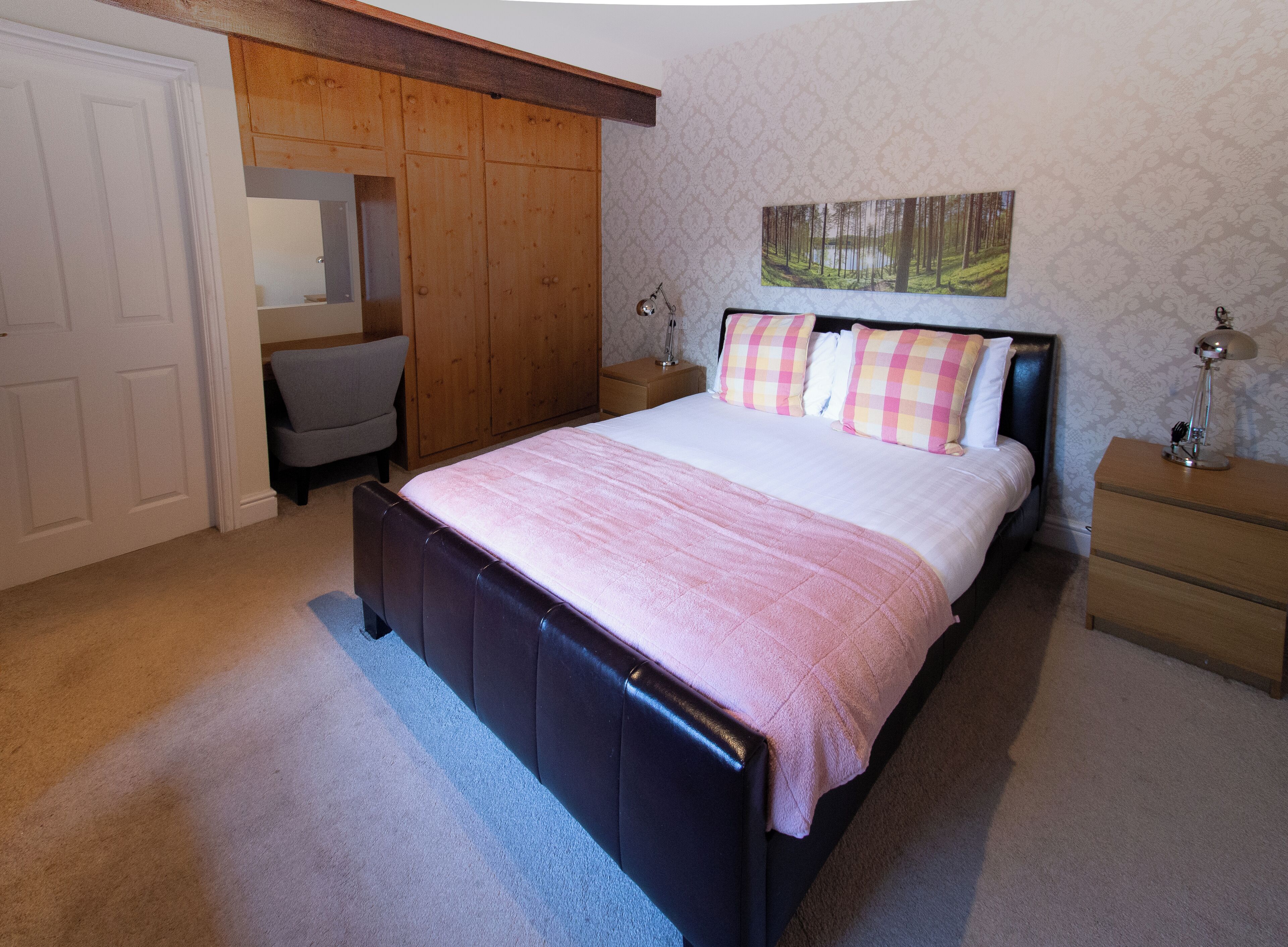 A bedroom with a bed, a chair, a nightstand, and a wardrobe.