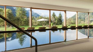 A pool area with a clear view of a mountainous landscape through large windows. - La Casies Mountain Living Hotel (Valle di Casies)