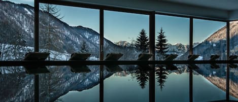 Una piscina techada, sillones reclinables de piscina