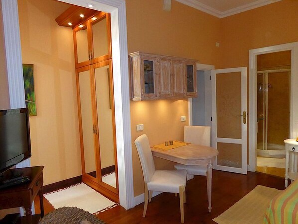 Un espacio habitable compacto con comedor, televisión y armario corredero.