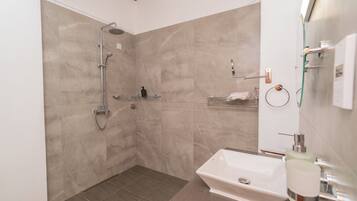 Ein modernes Badezimmer mit Dusche, Waschbecken und Toilette.