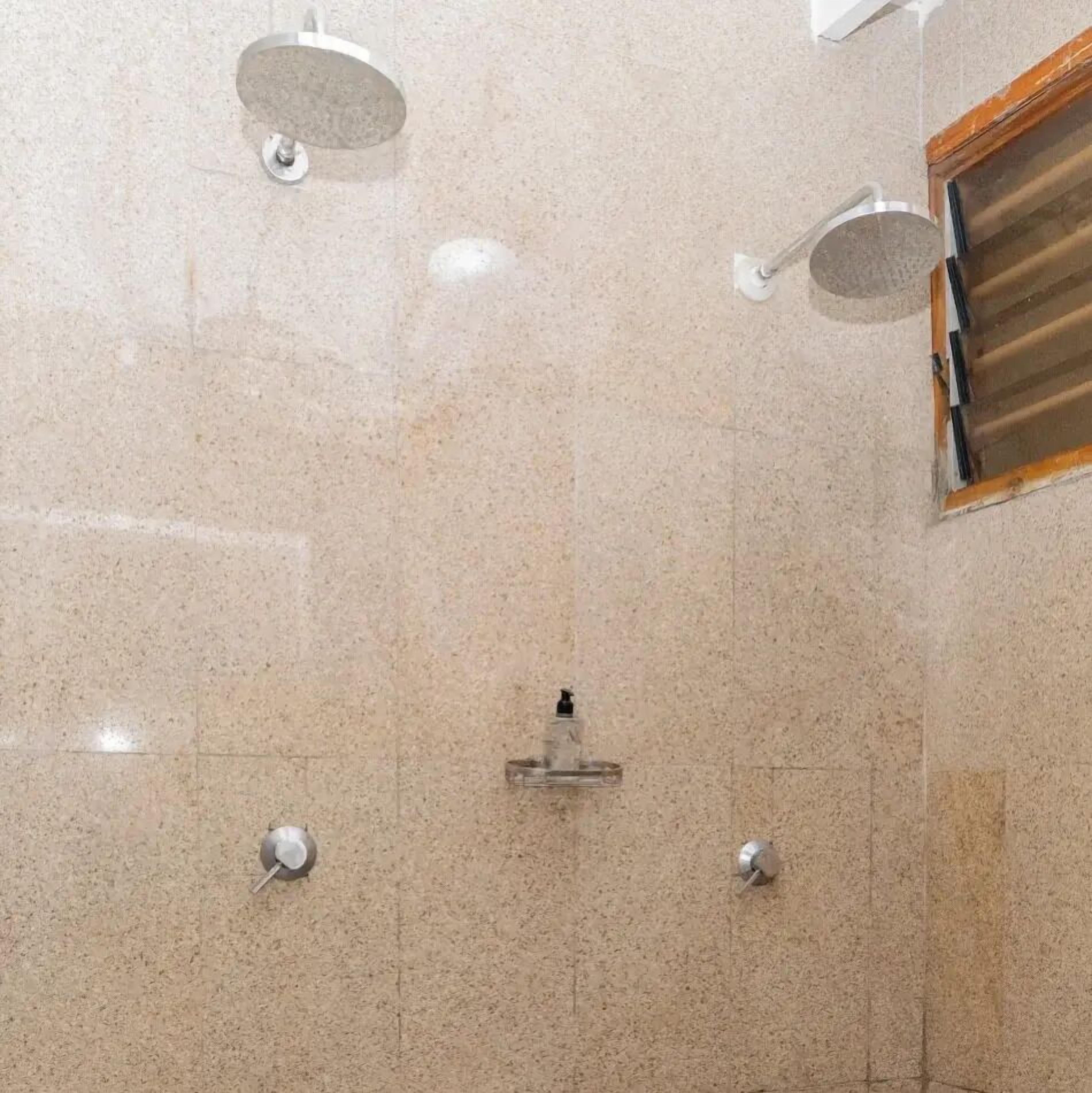 Uma casa de banho com uma área de duche espaçosa, uma banheira e uma sanita.