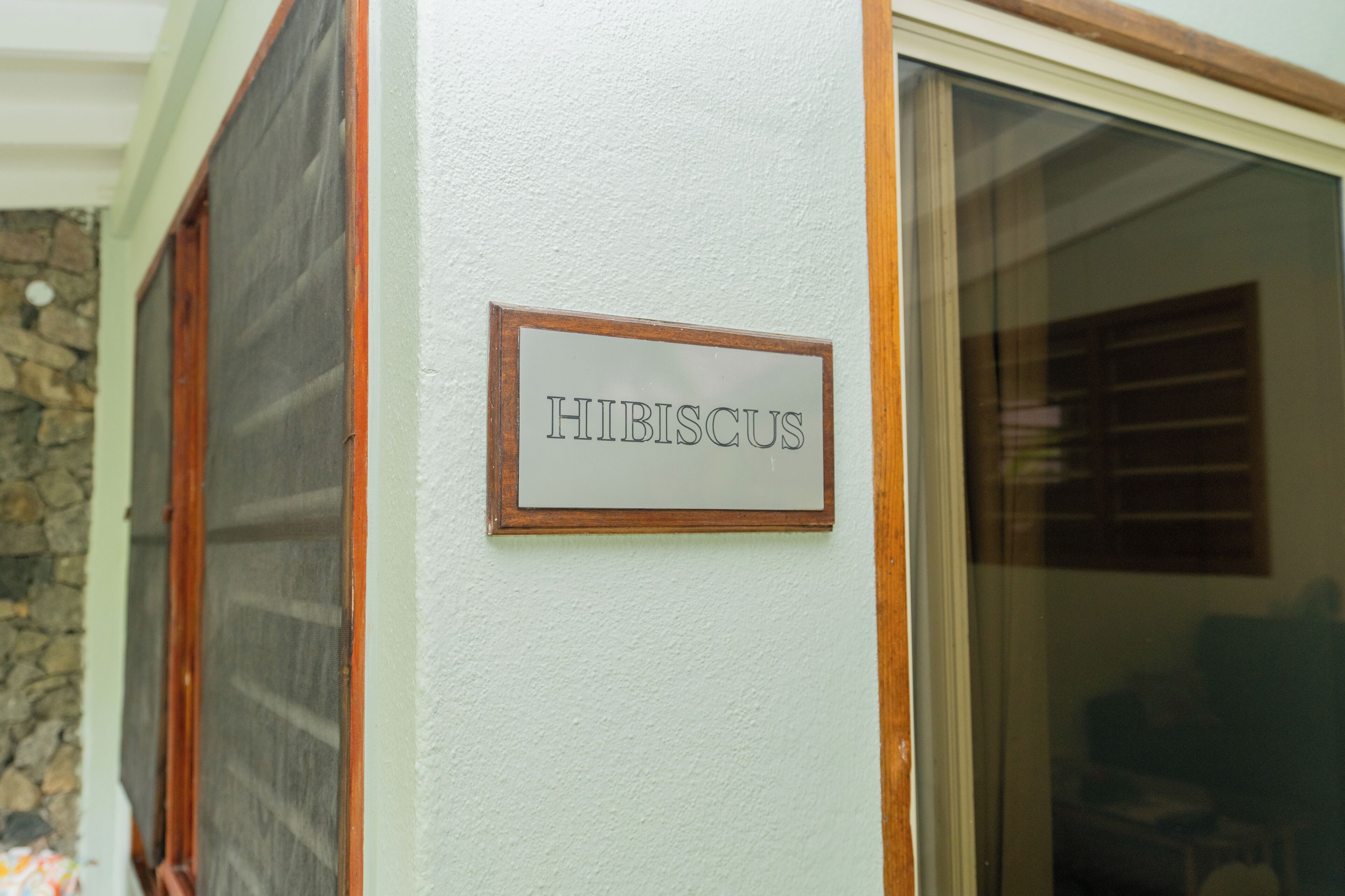 Una señal con el nombre 'HIBISCUS' en una pared.